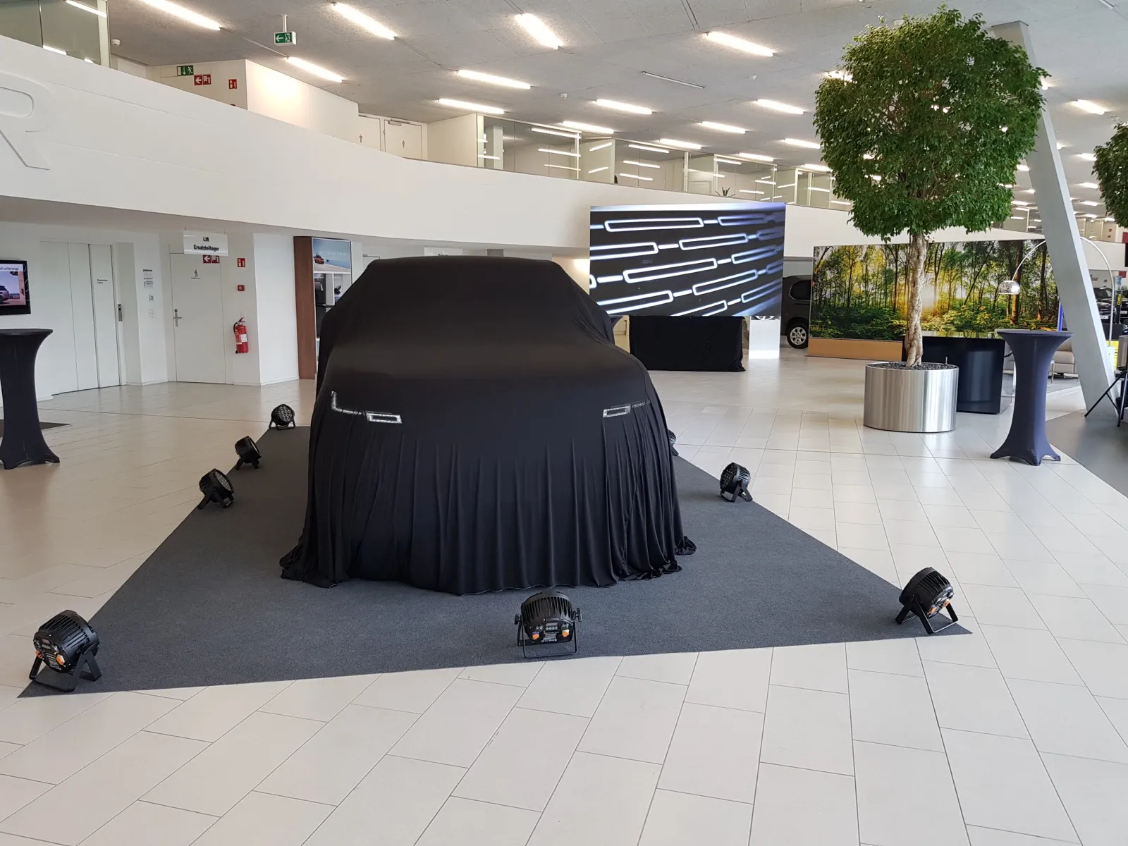 Produkteinführung im Autohaus mit beleuchtetem Fahrzeug, LED-Screen und Beschallung