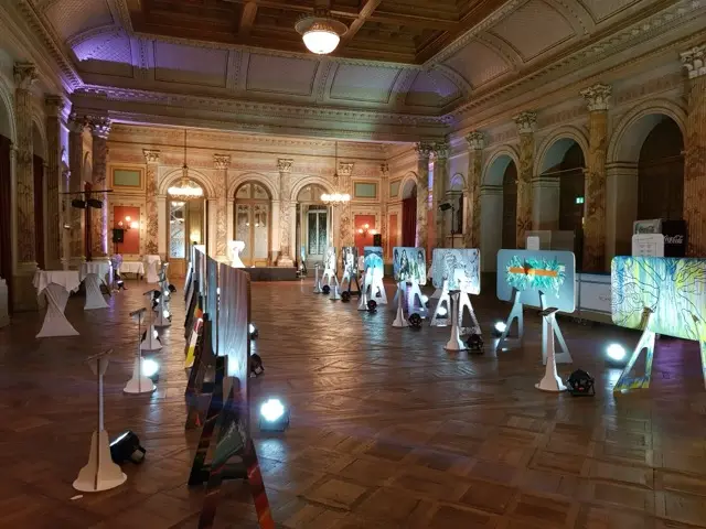 Vorstellung Prämierung bemalte Trennwände im Hotel Schweizerhof Luzern – Beleuchtung 25 Gemälde mit 50 Akku LED Scheinwerfern.